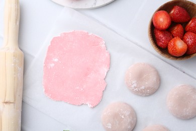 Photo of Tasty homemade mochi, dough and strawberries on white table, top view