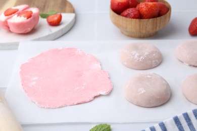 Photo of Tasty homemade mochi, dough and strawberries on table, closeup