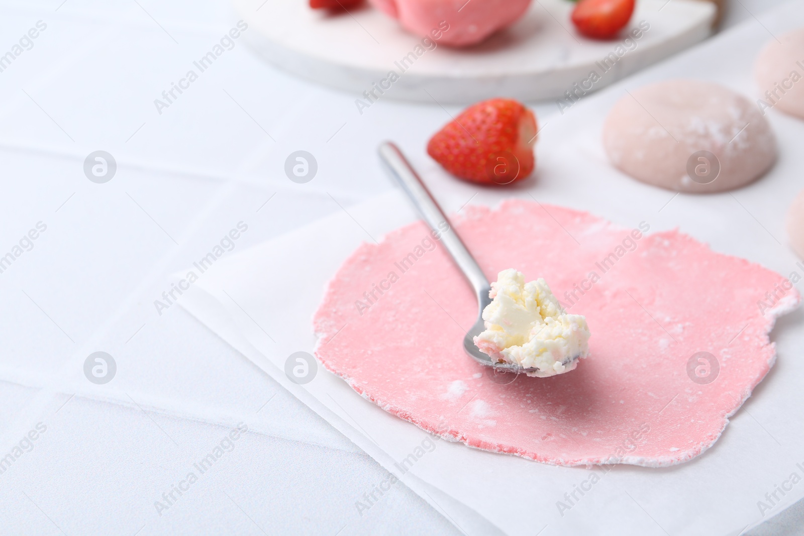 Photo of Dough for tasty homemade mochi and cream on white tiled table, closeup