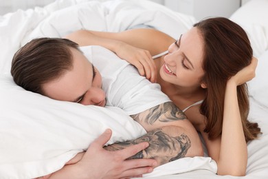 Happy couple spending time together on bed at home