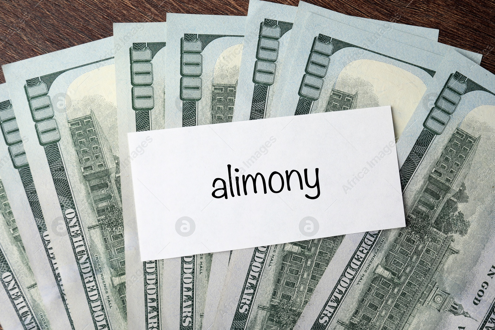 Photo of Alimony. Blank card and dollar banknotes on wooden table, top view