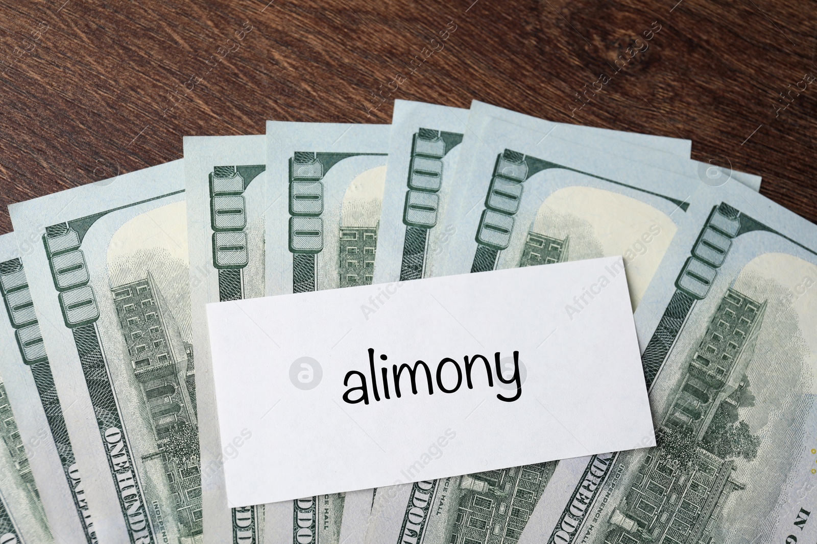 Photo of Alimony. Blank card and dollar banknotes on wooden table, top view