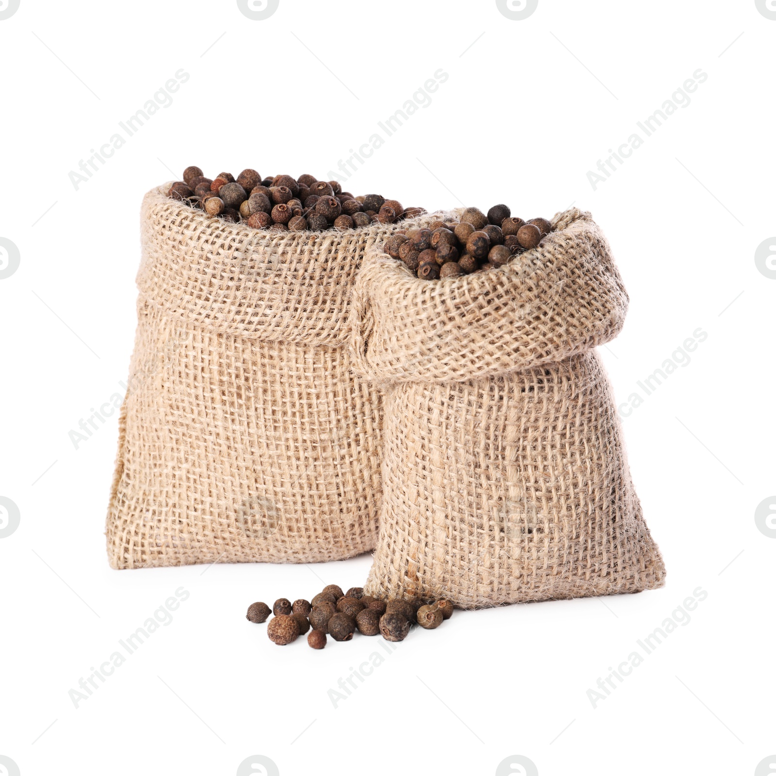 Photo of Burlap sacks with allspice isolated on white