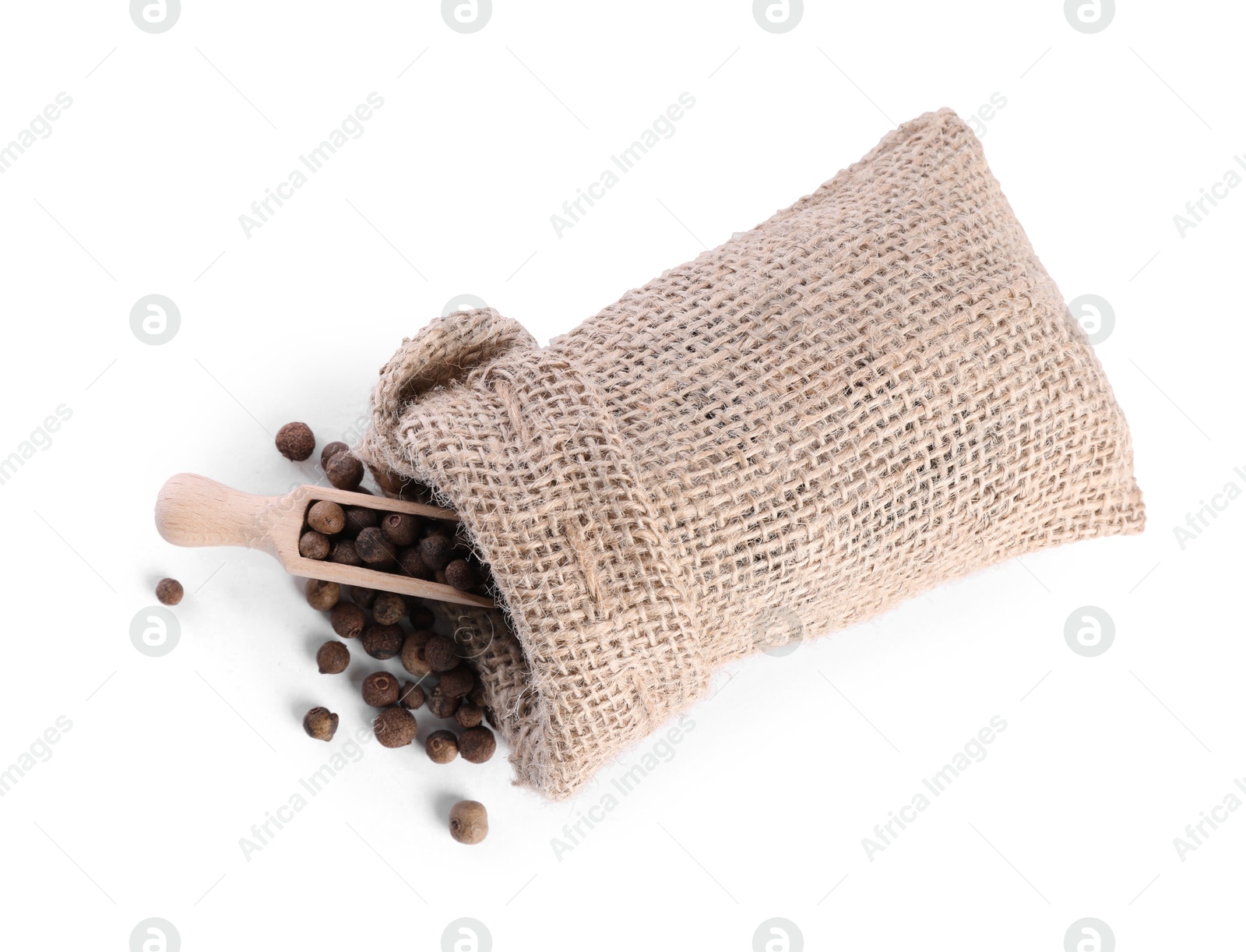 Photo of Burlap sack with allspice and scoop isolated on white, top view