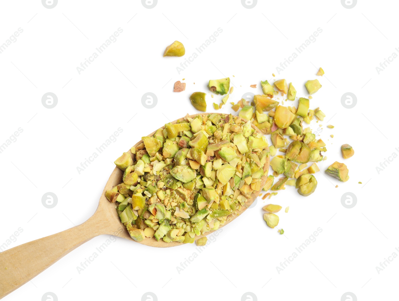 Photo of Pieces of peeled pistachio nut in wooden spoon isolated on white, top view