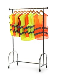 Photo of Different bright reflective vests on clothing rack isolated on white