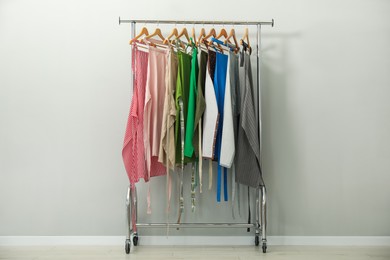 Photo of Aprons on clothing rack near light grey wall