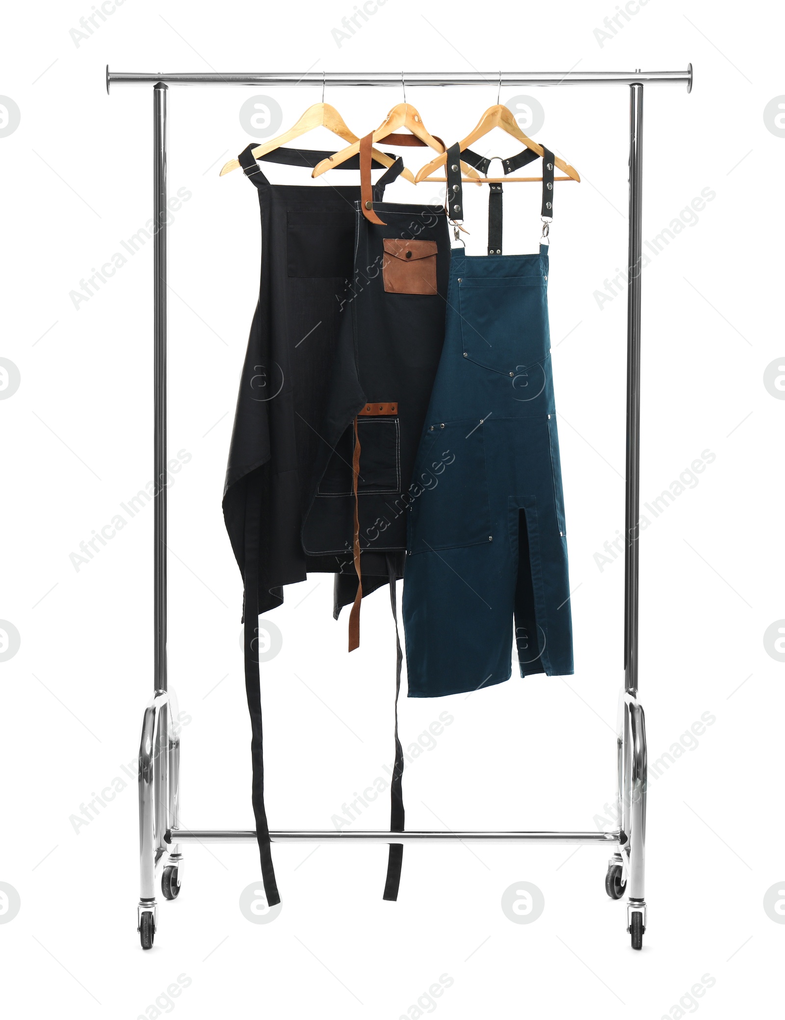 Photo of Three aprons on clothing rack isolated on white