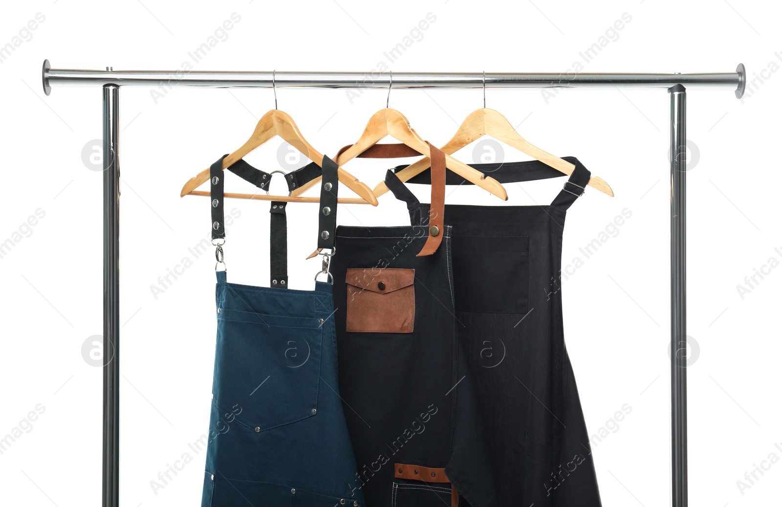 Photo of Three aprons on clothing rack isolated on white