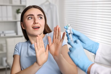 Dental phobia. Dentist with syringe and vial near scared woman in clinic, closeup