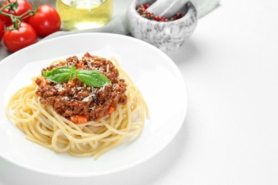 Photo of Delicious pasta bolognese on white table. Space for text