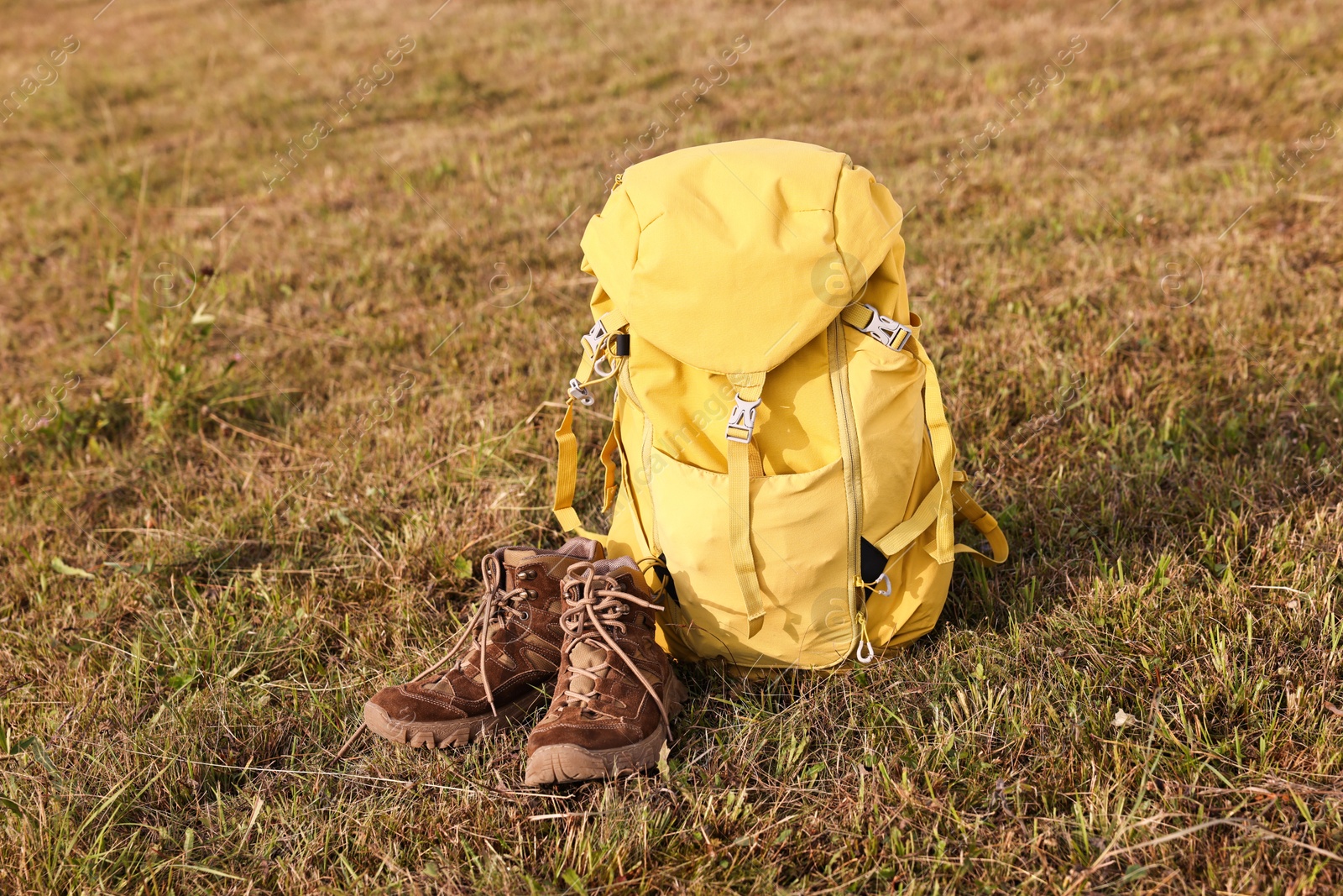 Photo of Backpack and trekking shoes on grass outdoors