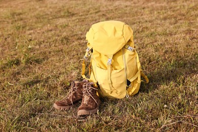 Backpack and trekking shoes on grass outdoors