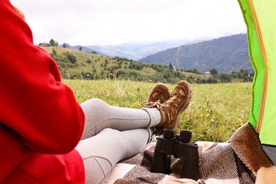 Photo of Woman wearing trekking shoes and lying in tent outdoors, closeup