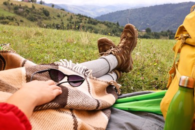 Woman wearing trekking shoes and lying in tent outdoors, closeup