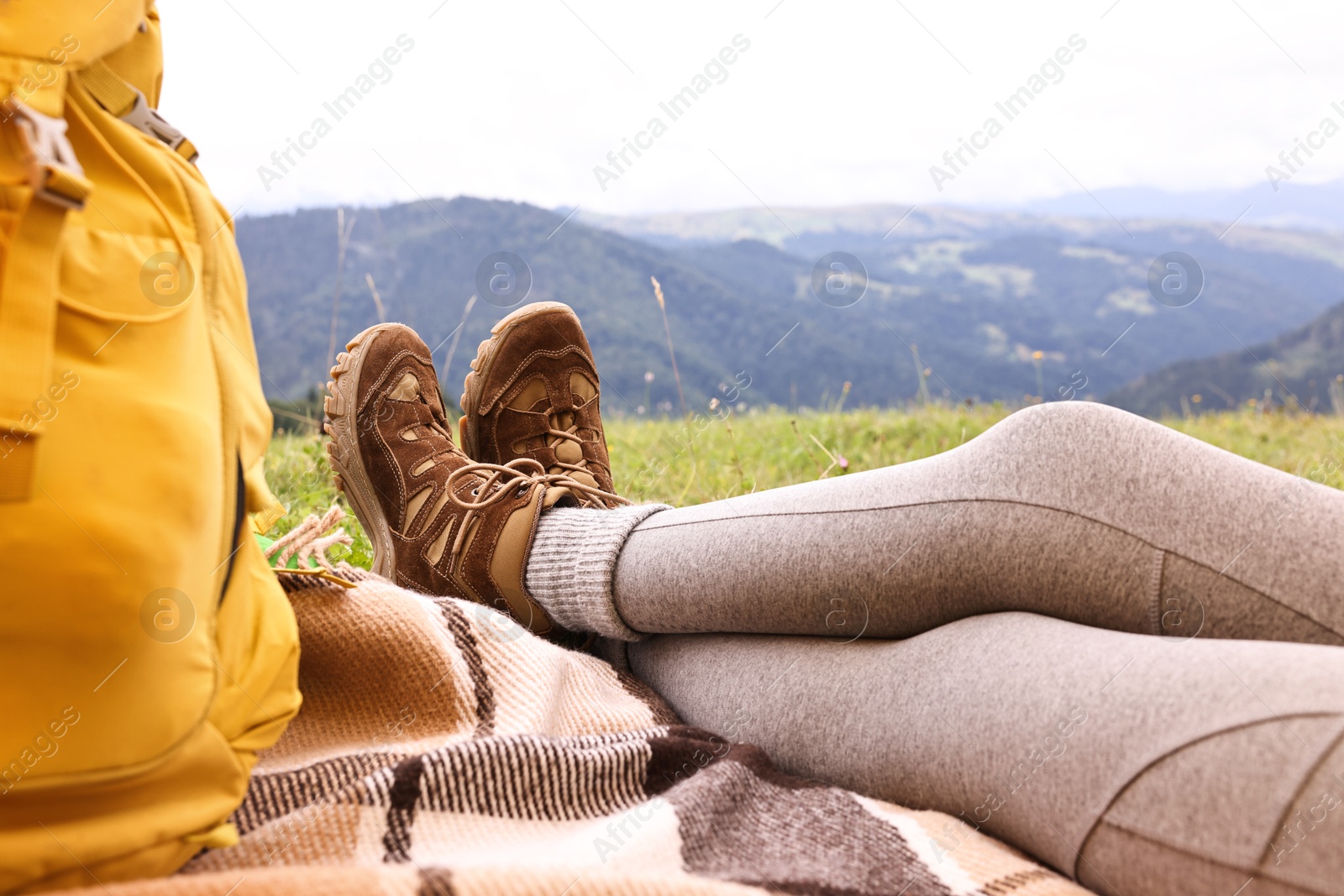 Photo of Woman wearing trekking shoes and lying in tent outdoors, closeup