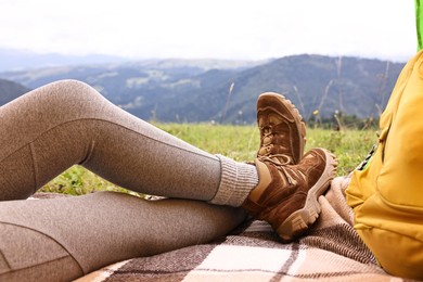 Woman wearing trekking shoes and lying in tent outdoors, closeup