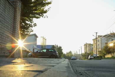 Photo of Beautiful view of city with trees and parked cars in morning