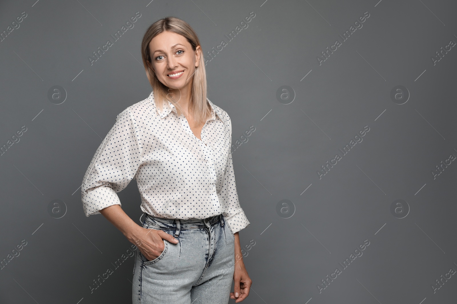 Photo of Portrait of beautiful smiling woman on grey background, space for text