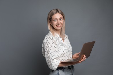 Photo of Beautiful woman with laptop on grey background