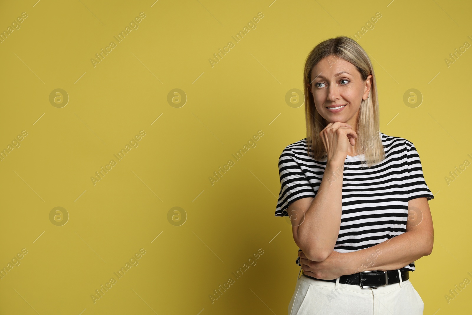 Photo of Portrait of beautiful smiling woman on yellow background, space for text