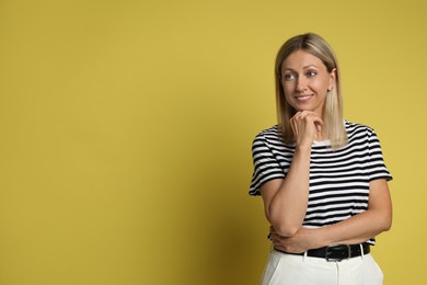 Photo of Portrait of beautiful smiling woman on yellow background, space for text