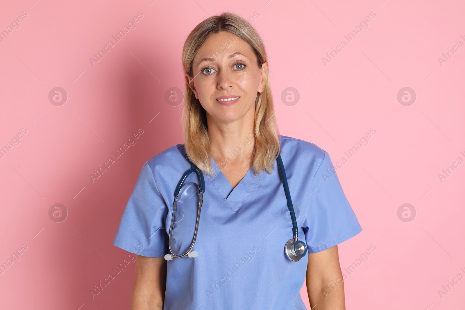 Photo of Portrait of doctor in medical uniform with stethoscope on pink background