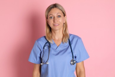 Photo of Portrait of doctor in medical uniform with stethoscope on pink background