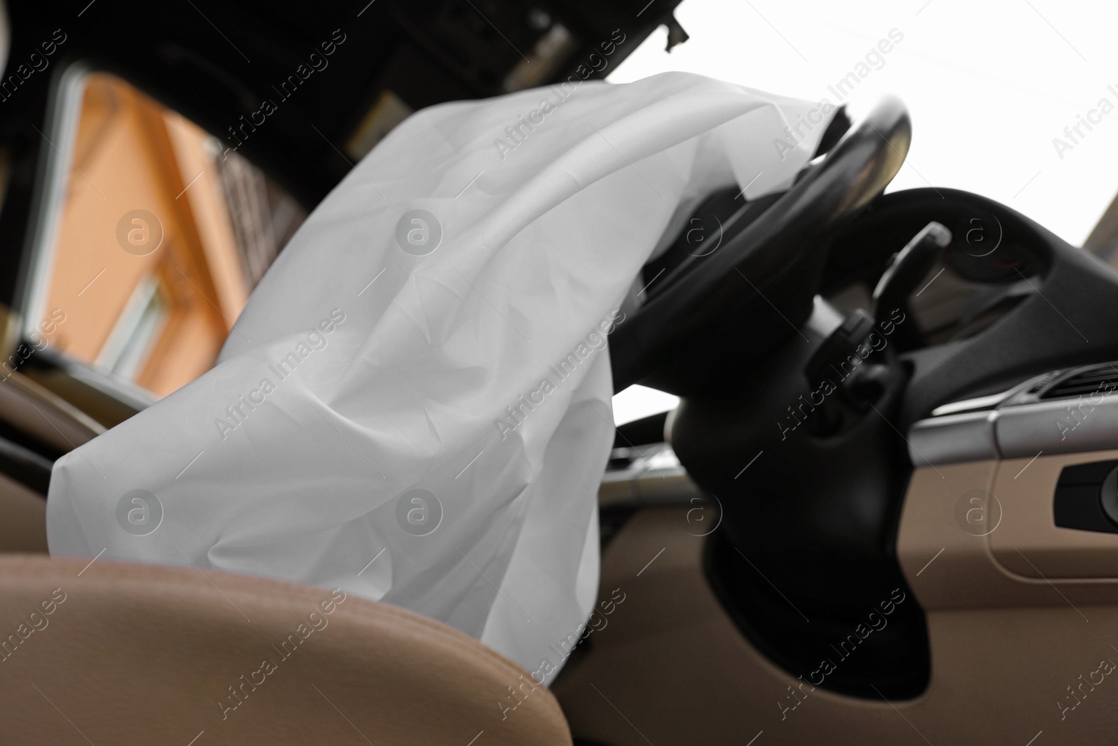 Photo of Opened airbag in automobile, closeup. Car safety equipment