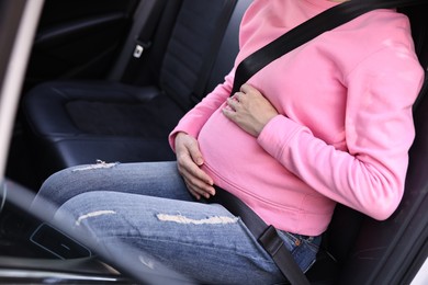 Photo of Pregnant woman with safety belt in car, closeup