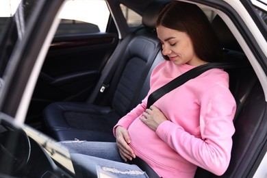 Pregnant woman with safety belt in car