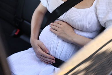 Pregnant woman with safety belt in car, closeup