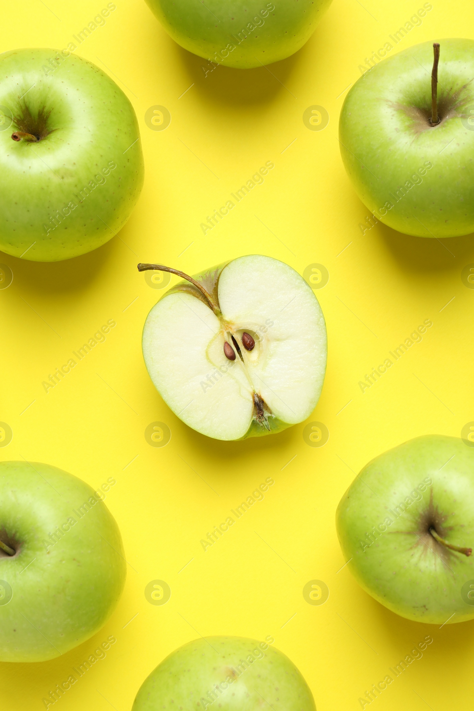 Photo of Flat lay composition with half of apple surrounded by ones on yellow background