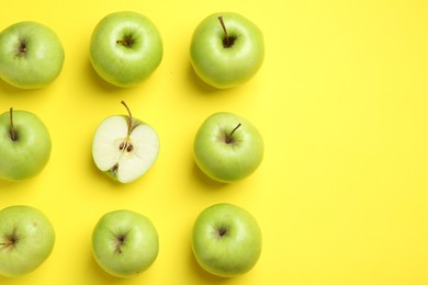 Photo of Flat lay composition with half of apple surrounded by ones on yellow background. Space for text