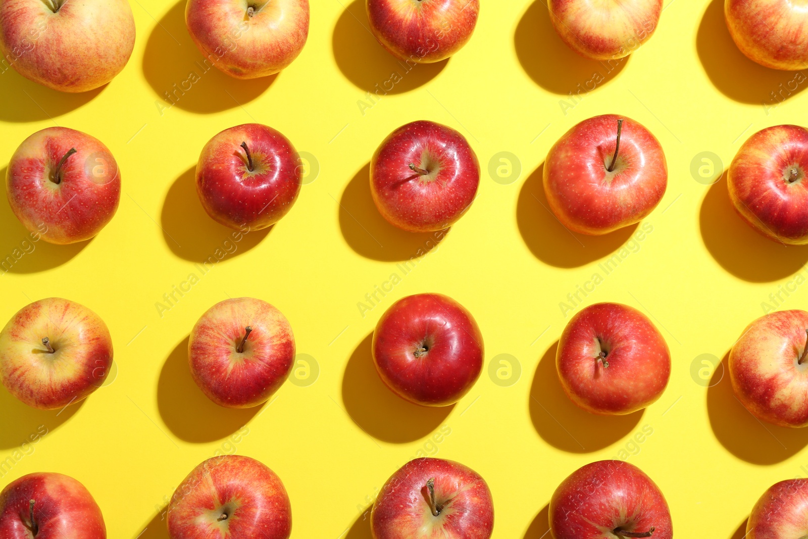 Photo of Flat lay composition with many red apples on yellow background