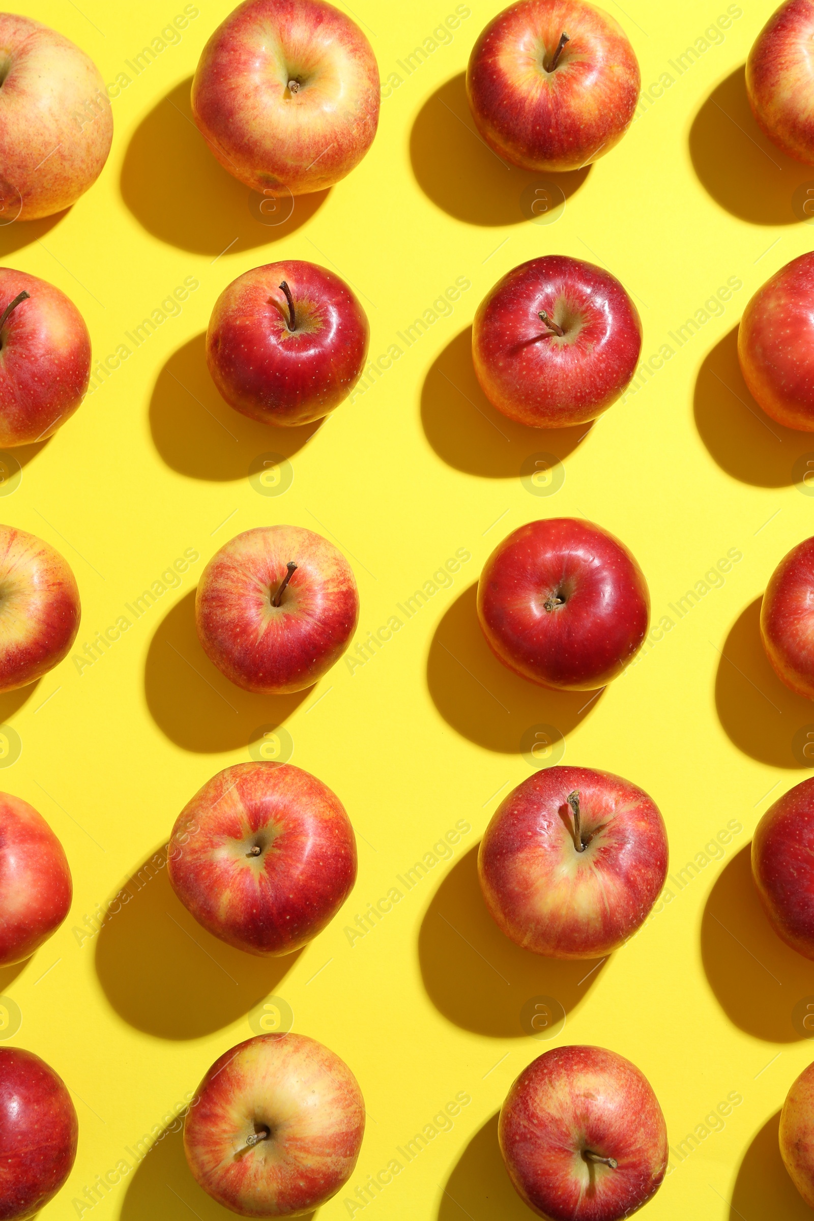 Photo of Flat lay composition with many red apples on yellow background