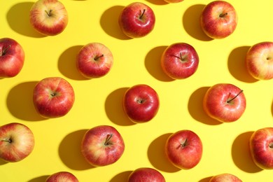 Flat lay composition with many red apples on yellow background