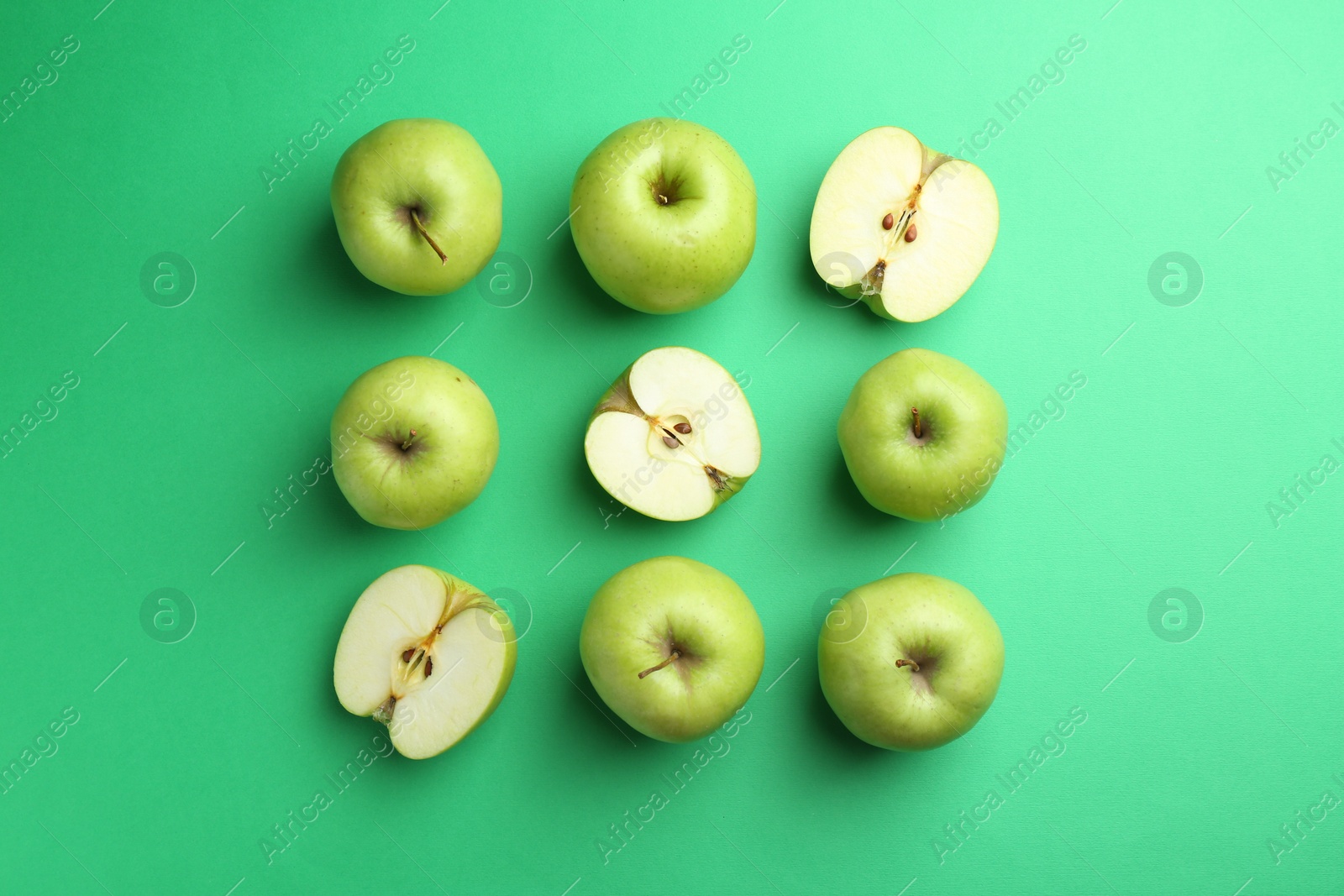 Photo of Flat lay composition with whole and cut apples on green background