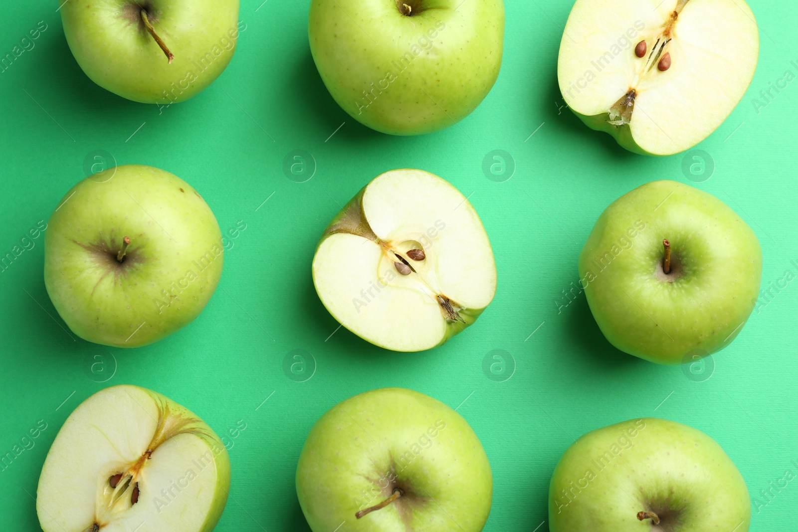 Photo of Flat lay composition with whole and cut apples on green background