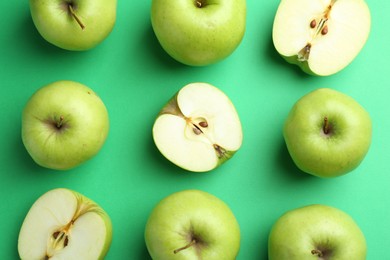 Photo of Flat lay composition with whole and cut apples on green background