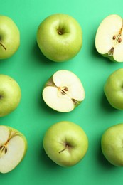 Photo of Flat lay composition with whole and cut apples on green background