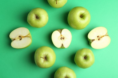 Photo of Flat lay composition with whole and cut apples on green background