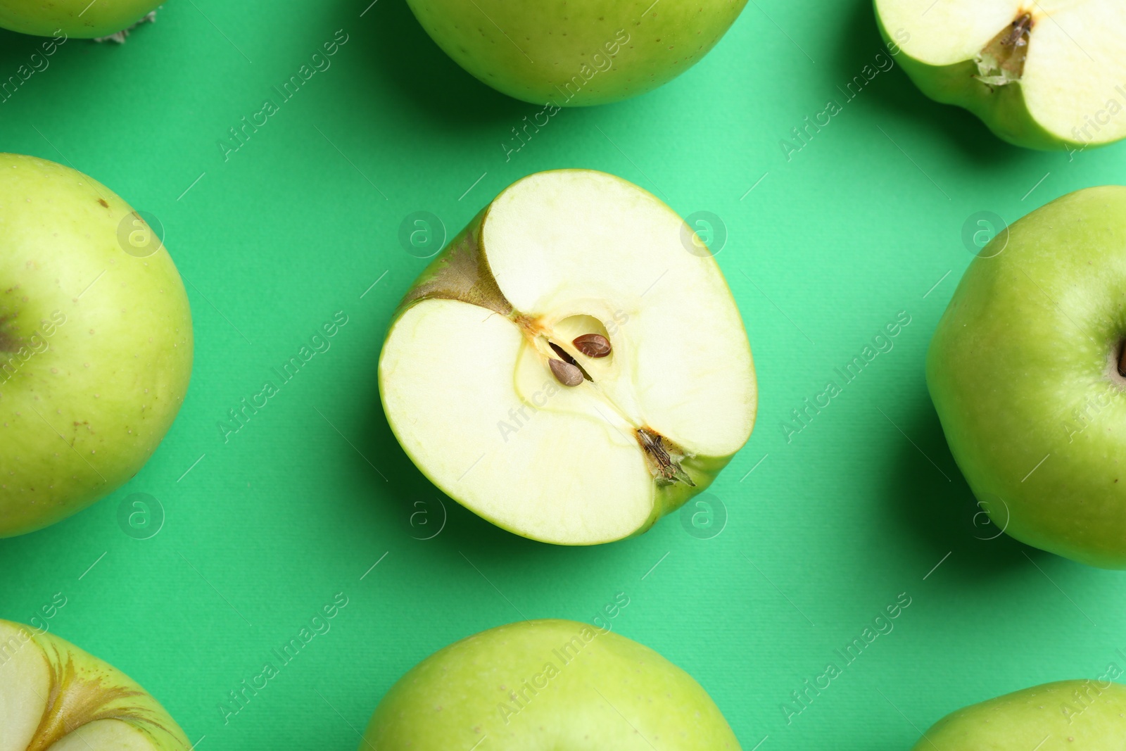 Photo of Flat lay composition with whole and cut apples on green background