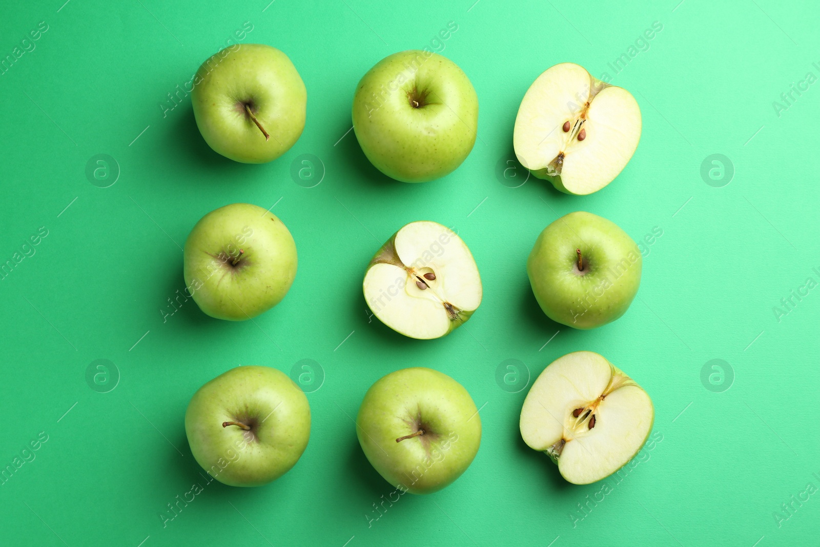 Photo of Flat lay composition with whole and cut apples on green background