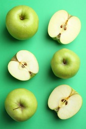 Photo of Flat lay composition with whole and cut apples on green background