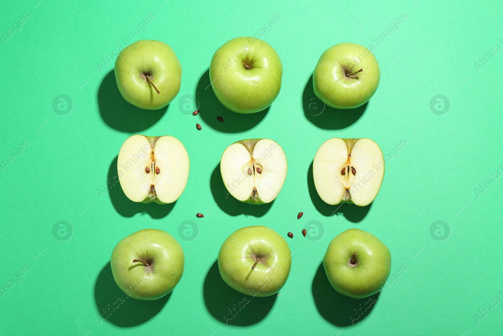 Photo of Flat lay composition with whole, cut apples and seeds on green background