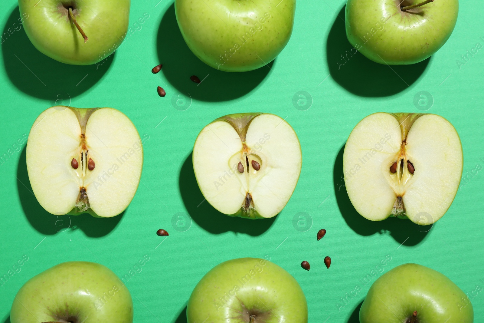 Photo of Flat lay composition with whole, cut apples and seeds on green background