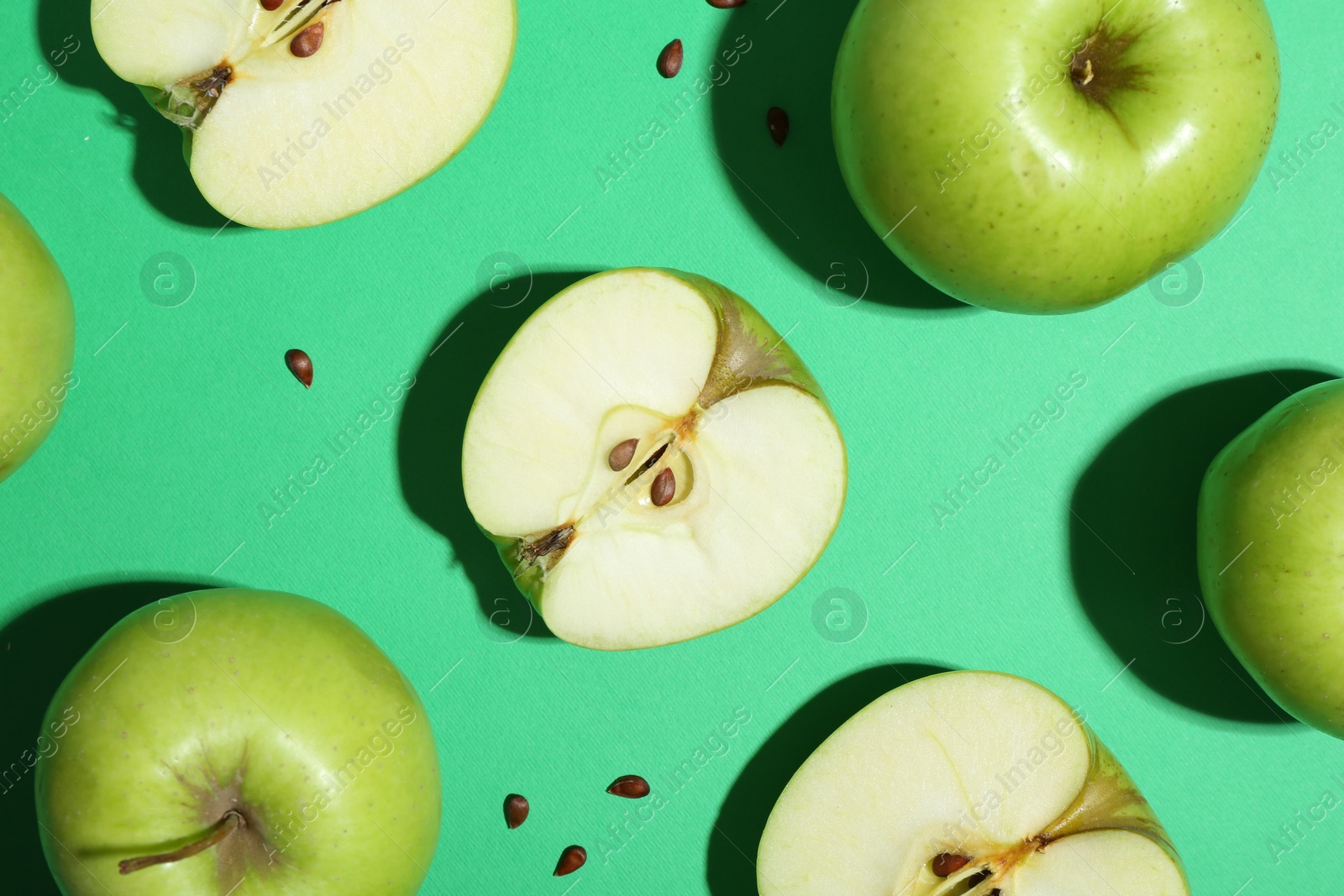 Photo of Flat lay composition with whole, cut apples and seeds on green background