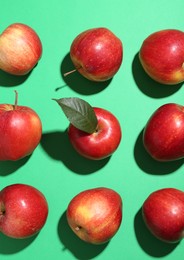 Photo of Red apples on green background, flat lay