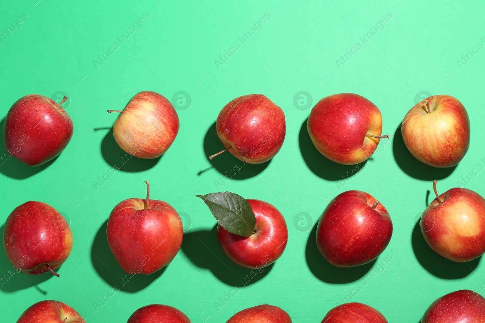 Photo of Red apples on green background, flat lay